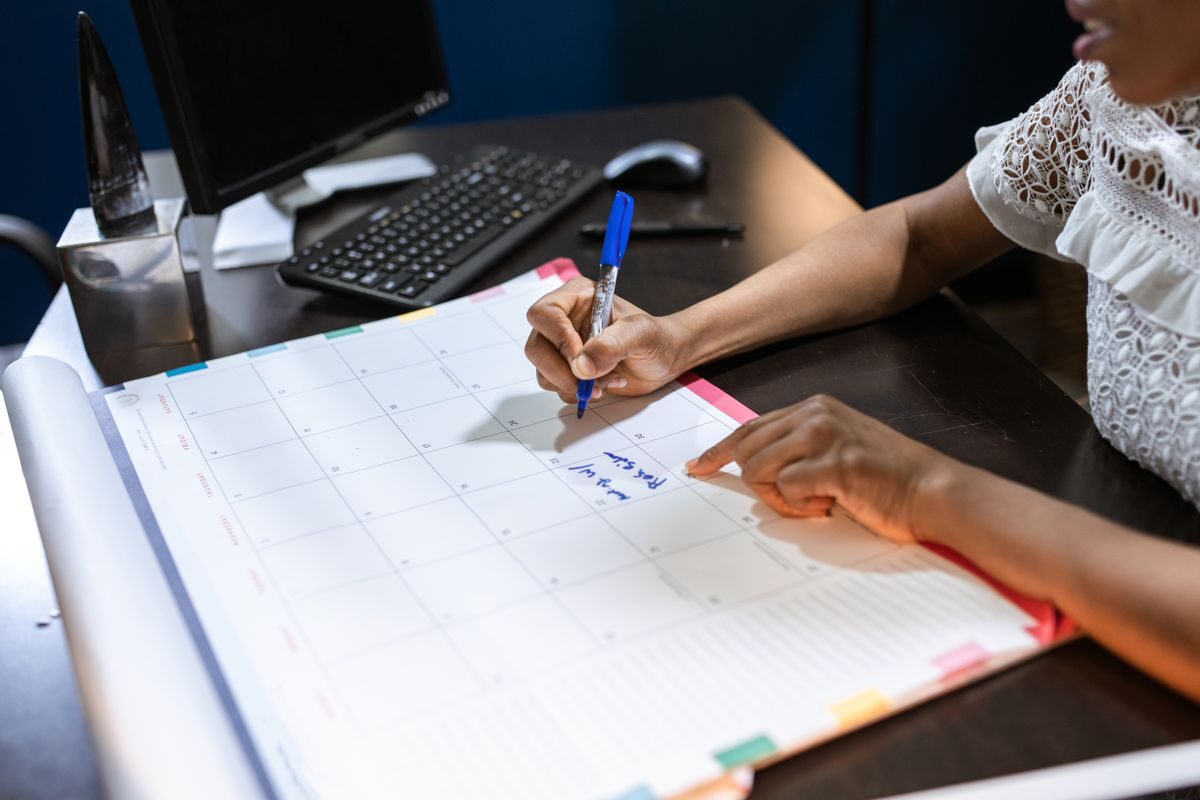Freelance annotant un planning mensuel pour distinguer les jours facturés des jours non facturés